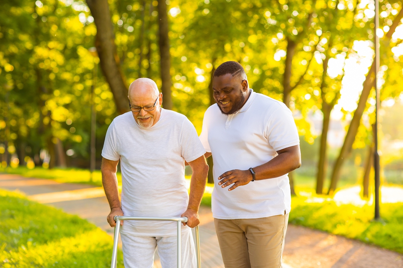 Caregiver walking with elderly man